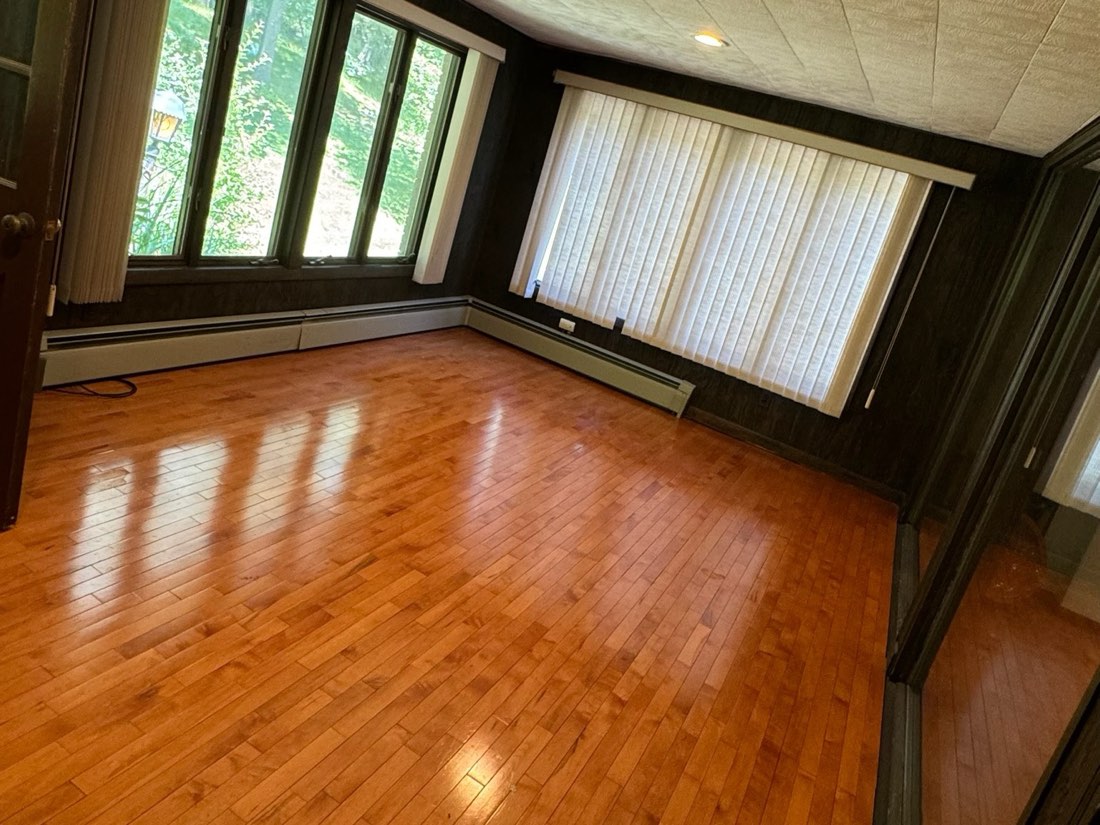 Hardwood floors and trim brought back in a bay-window room