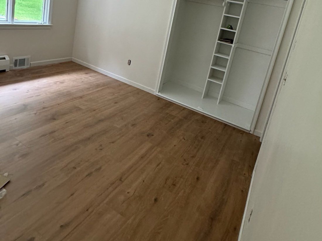 New laminate flooring in a freshly painted room with a fitted closet