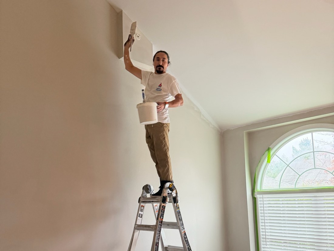 Prime Paint painter cutting in a ceiling line with the room covered