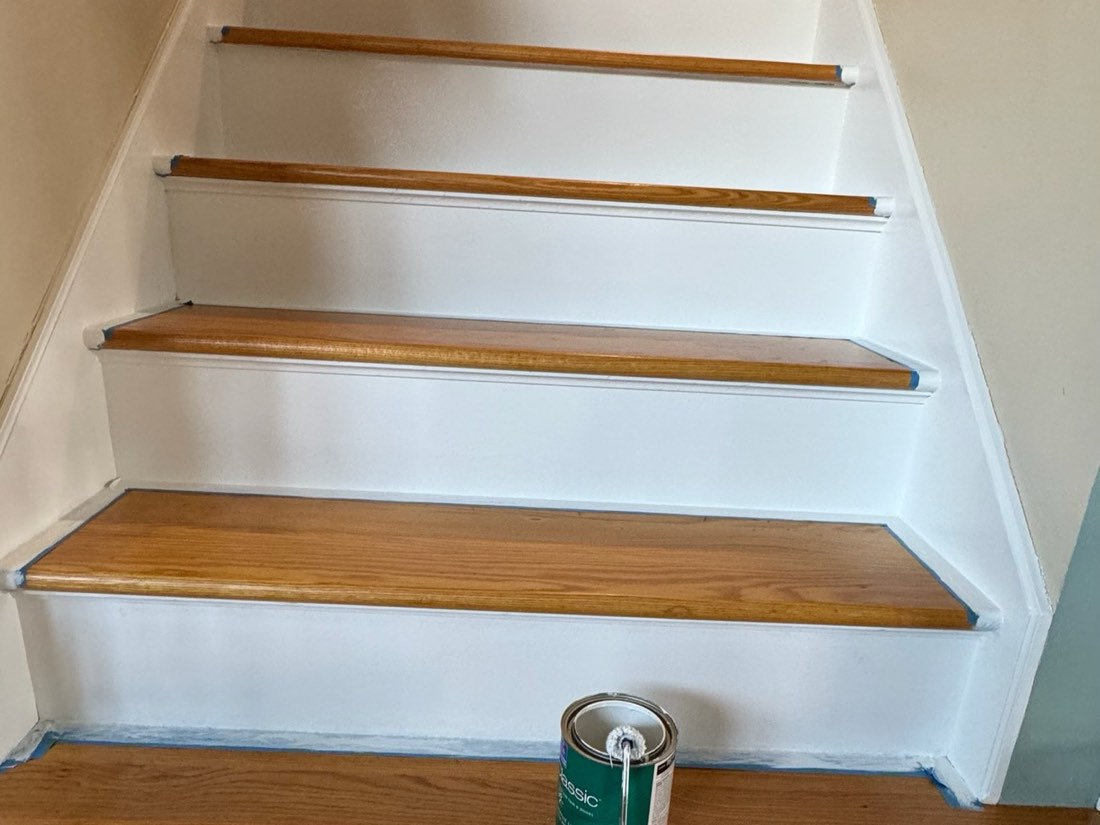 Stair risers and stringers painted white against wood treads