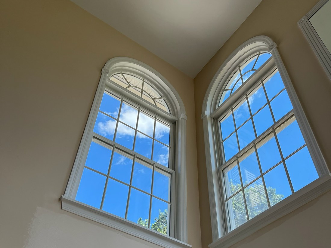 Arched windows and trim painted on a two-story wall