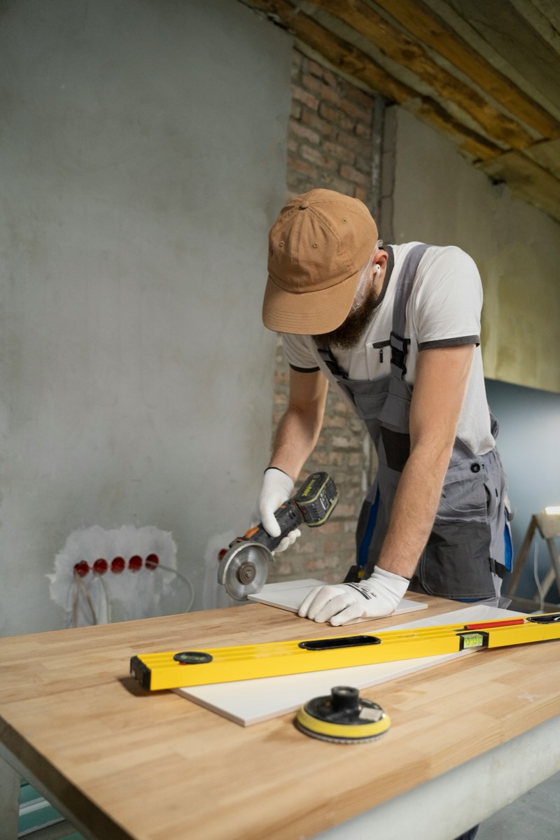 Handyman cutting and measuring a board during a home renovation